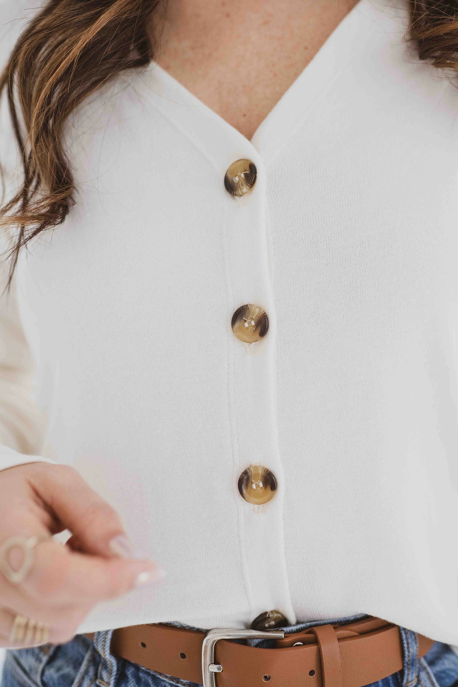 Close up detail of the buttons on the Holly Cropped Cardigan by Ang Hill in Vanilla, a v-neck cardigan with drop sleeves and tortoiseshell buttons.