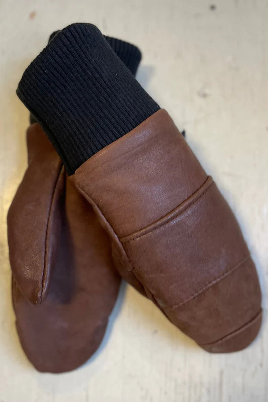 A pair of brown Lhasa mittens with ribbed cuffs, made from recycled leather, and lined with fleece.