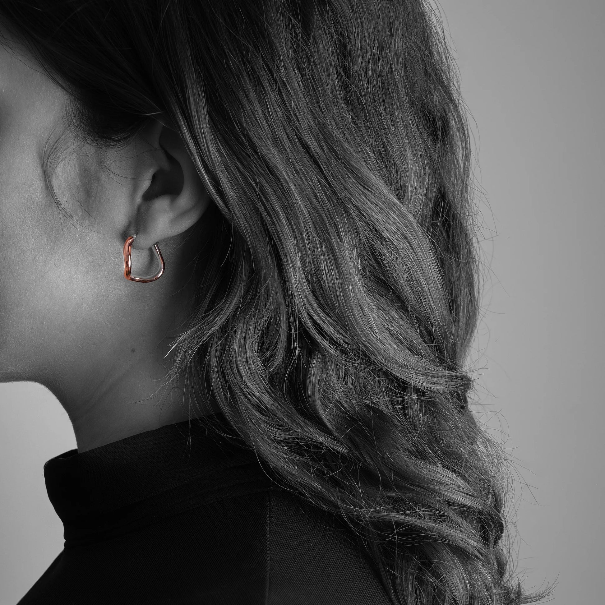 Close-up of an ear wearing a Copper silverl lined earring with a blurred background