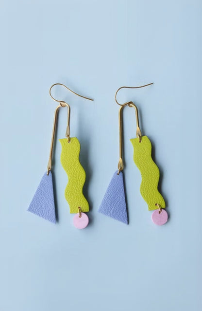 Pair of earrings with colorful geometric shapes on a light blue background