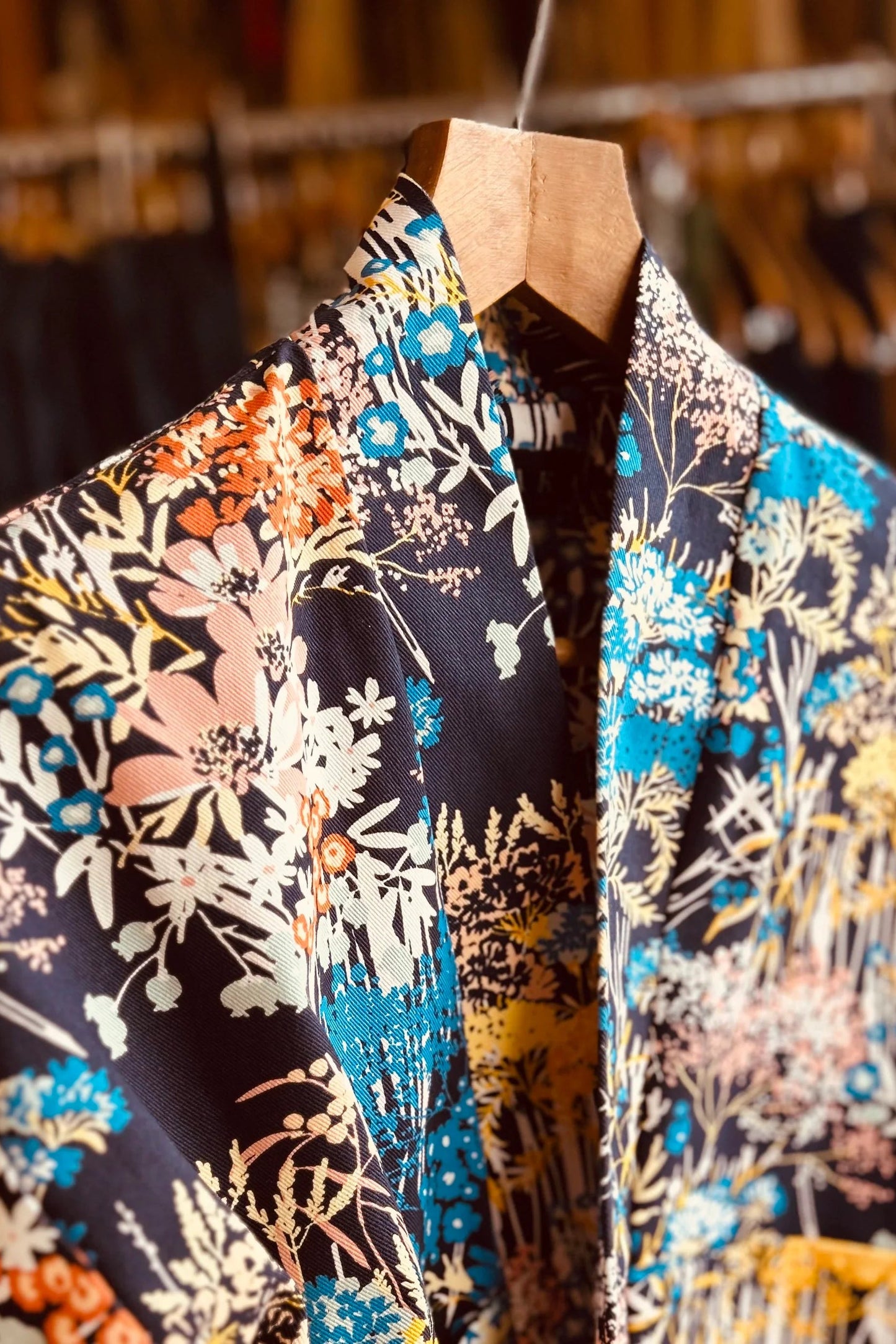 The Magnolia Jacket from Kazak in Prairie print, a kimono style jacket with 3/4 sleeves and large patch pockets, is shown on a hanger