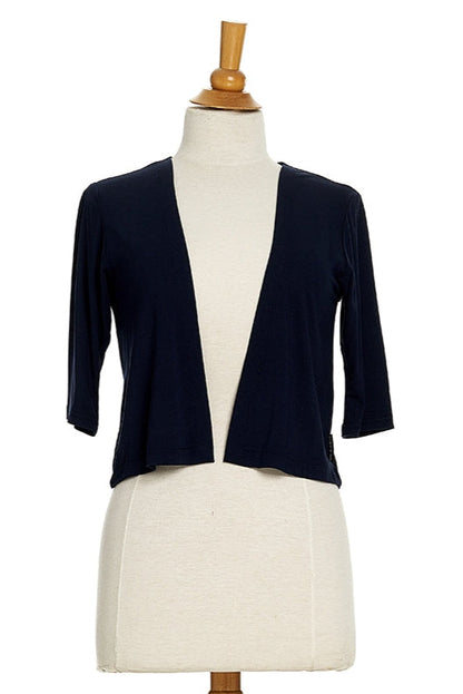 The Salvador Bolero in Black from Rien ne se Perd, featuring 3/4 sleeves and an angled hem, is shown on a mannequin in front of a white background. 