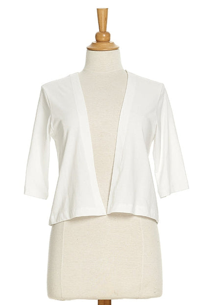 The Salvador Bolero in White from Rien ne se Perd, featuring 3/4 sleeves and an angled hem, is shown on a mannequin in front of a white background. 