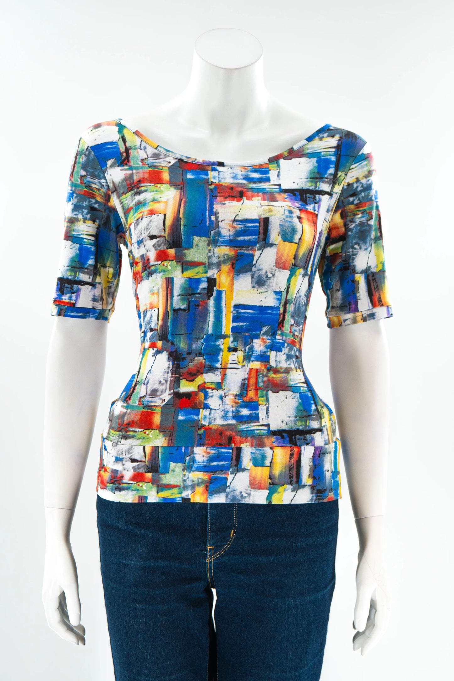 The Colori T-Shirt by Karkass in Multicolour, featuring an abstract brushstroke pattern, wide neck, and mid-length sleeves, is shown with jeans on a mannequin in front of a white background. 