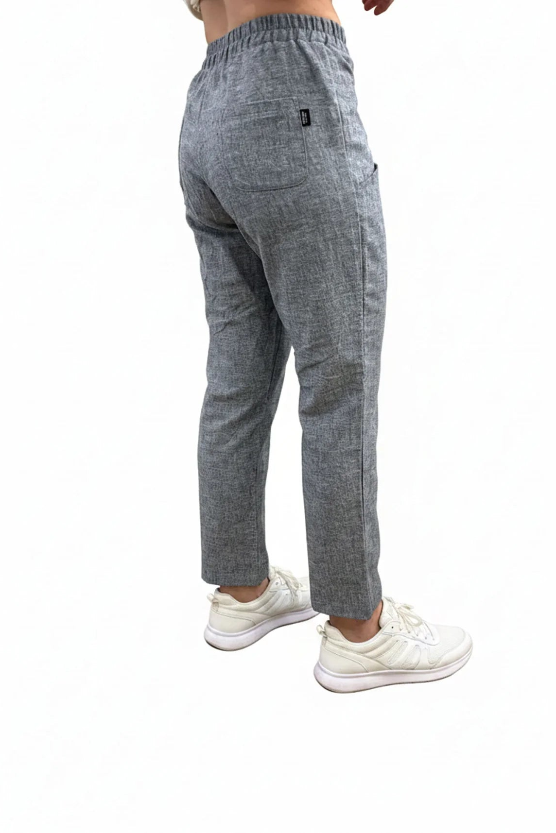 Back waist down view of a woman wearing the Cantley Short Pants by Message Factory in Natural Blue, slim cut capri pants with an elastic waist. She is standing in front of a plain background. 
