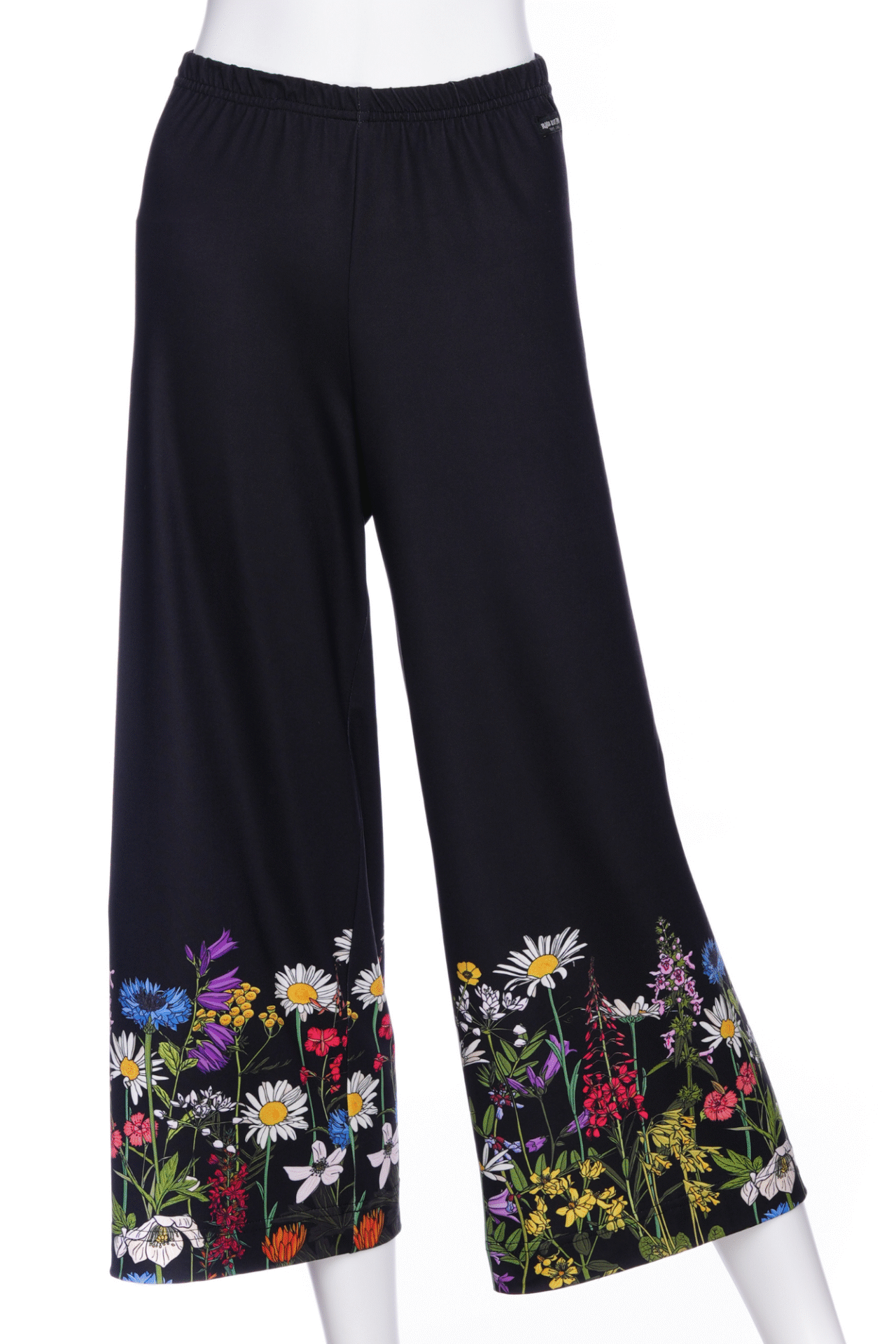 The Amaretto 7/8 Gaucho Pants from Rien ne se Perd in Black with a floral print hem are shown on a mannequin in front of a white background. 