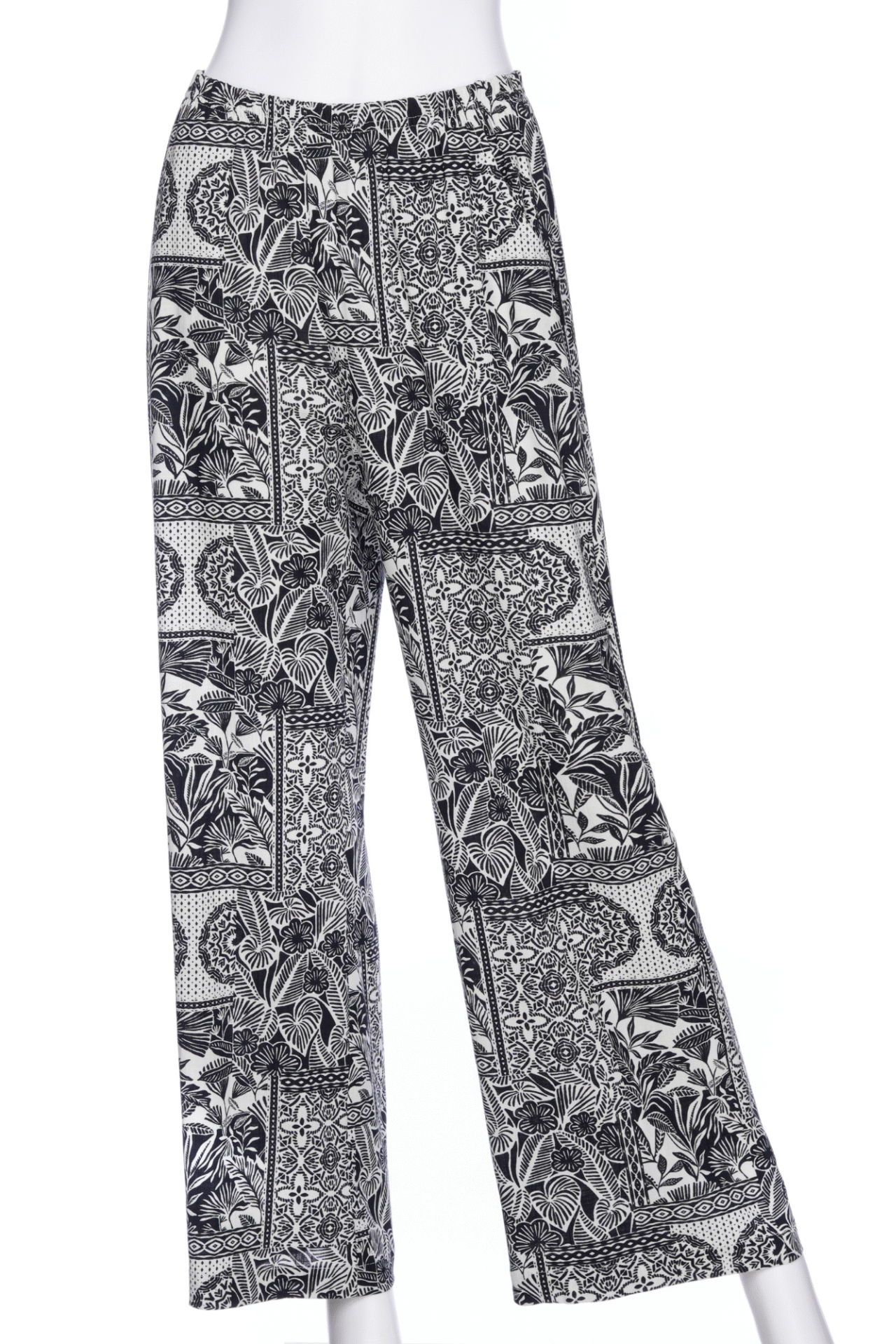 The Mango Pants from Rien ne se Perd in Black/Ivory tropical print, palazzo pants with an elastic waist and pockets, are show on a mannequin in front of a white background. 