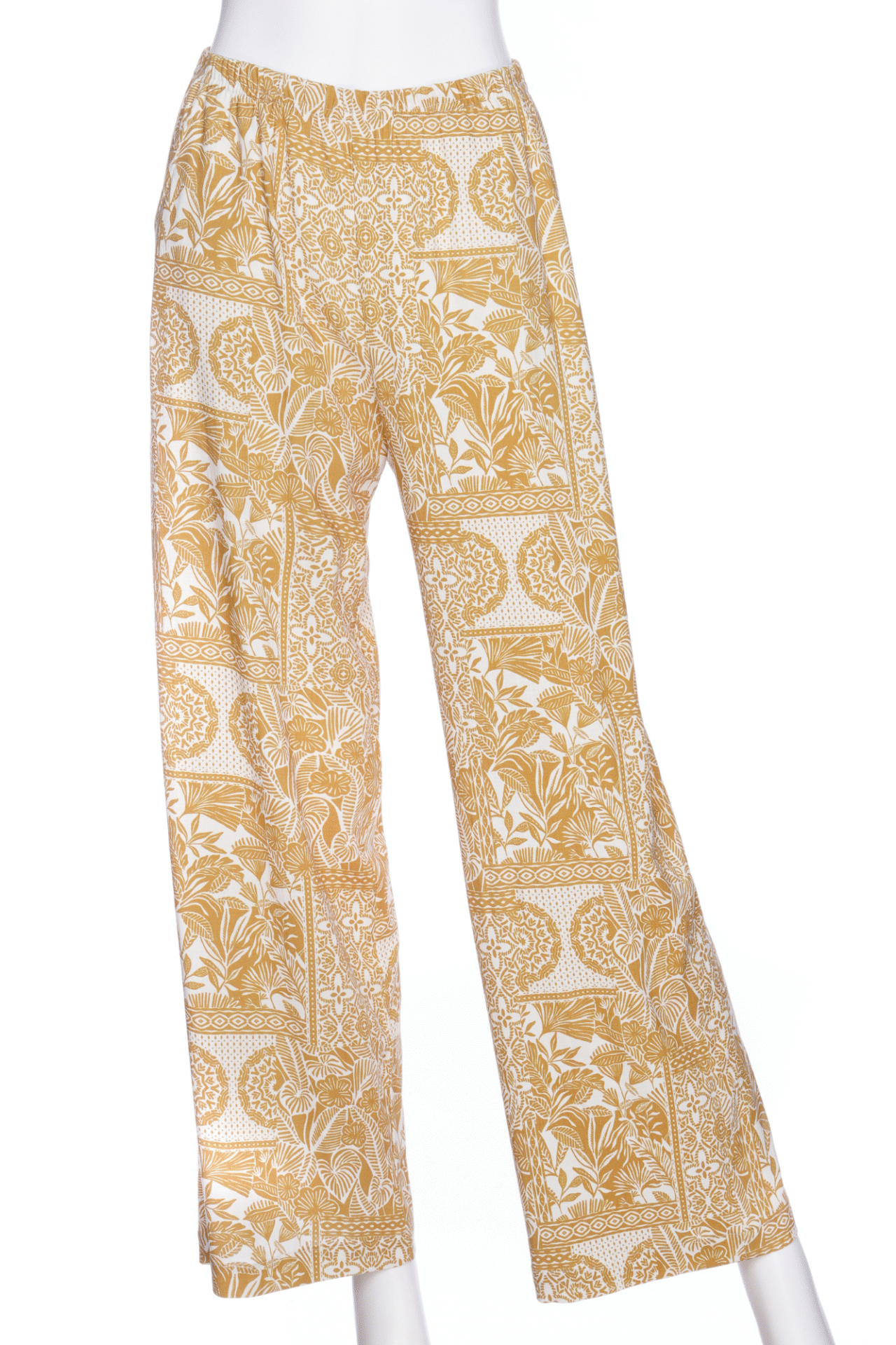 The Mango Pants from Rien ne se Perd in Ocre/Ivory tropical print, palazzo pants with an elastic waist and pockets, are show on a mannequin in front of a white background. 