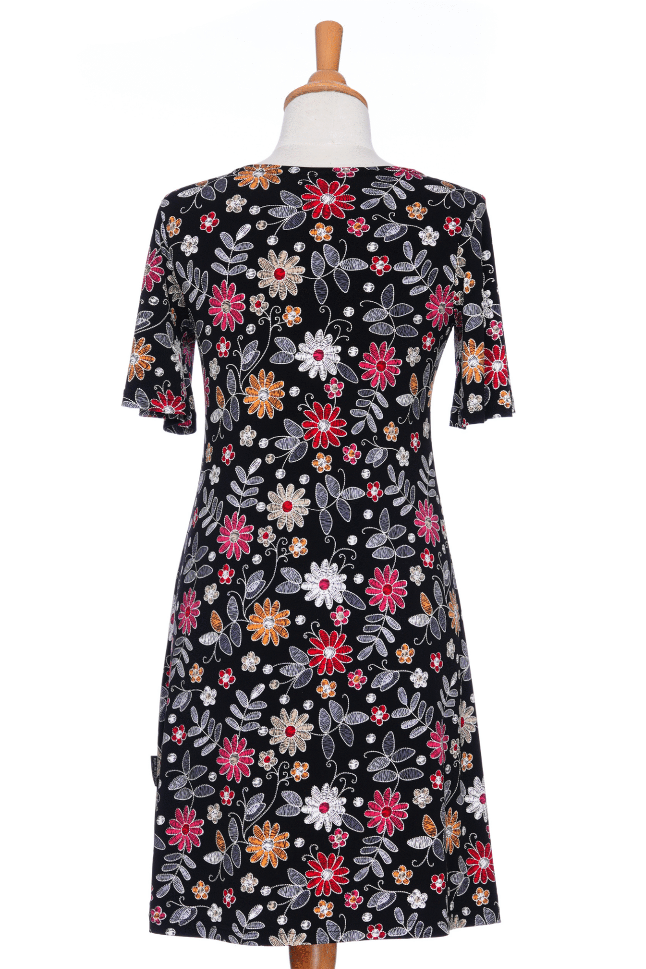 Back view of the Grenadine Dress by Rien ne se Perd in Floral print, a short A-line dress with bell sleeves and a scoop neck, is shown on a mannequin in front of a white background. 