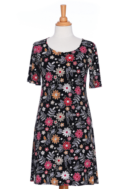 The Grenadine Dress by Rien ne se Perd in Floral print, a short A-line dress with bell sleeves and a scoop neck, is shown on a mannequin in front of a white background. 
