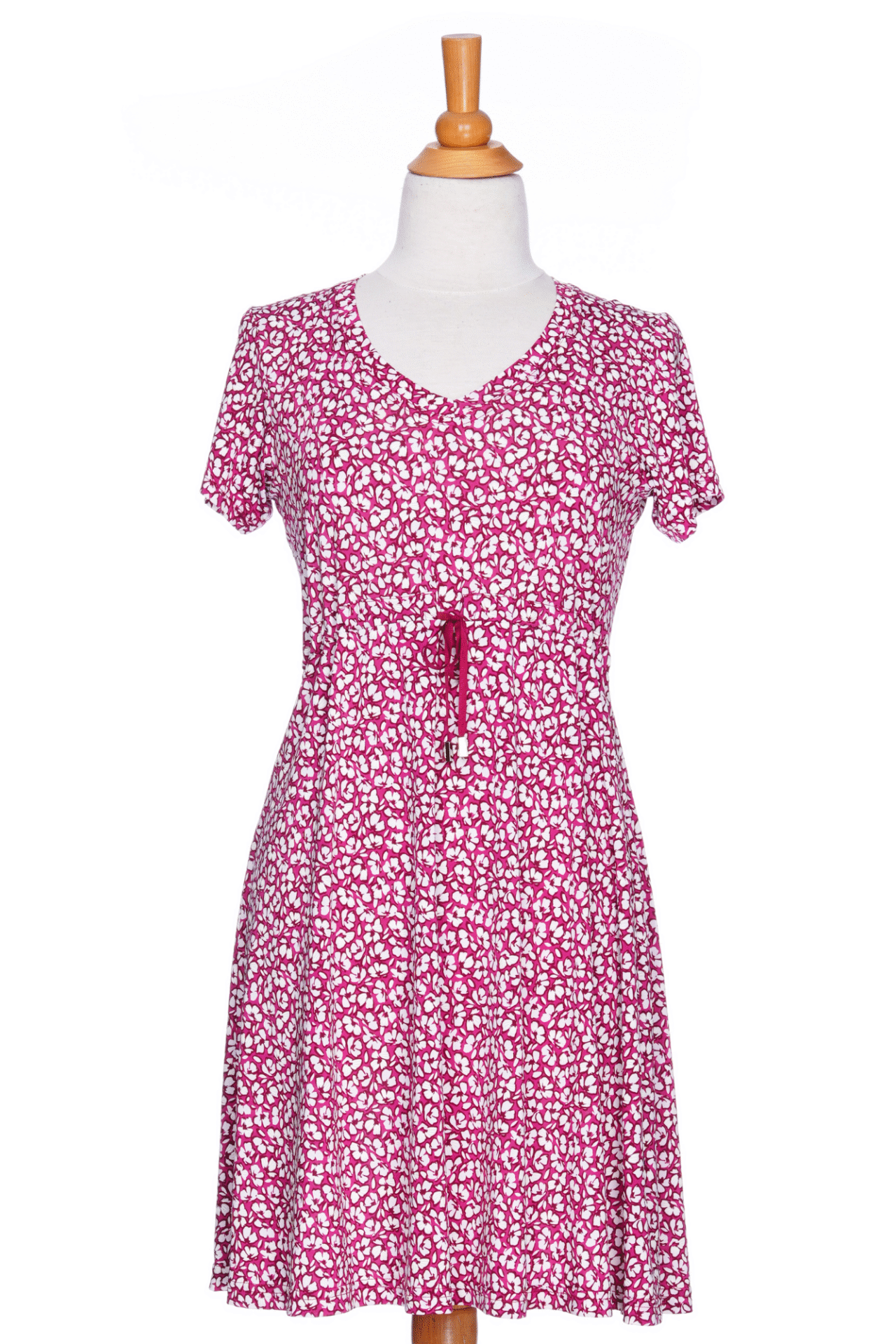 The Sangria Dress by Rien ne se Perd in Raspberry floral print, a short dress with a V-neck, an adjustable drawstring ribbon under the bust, and short sleeves, is shown on a mannequin against a white background. 